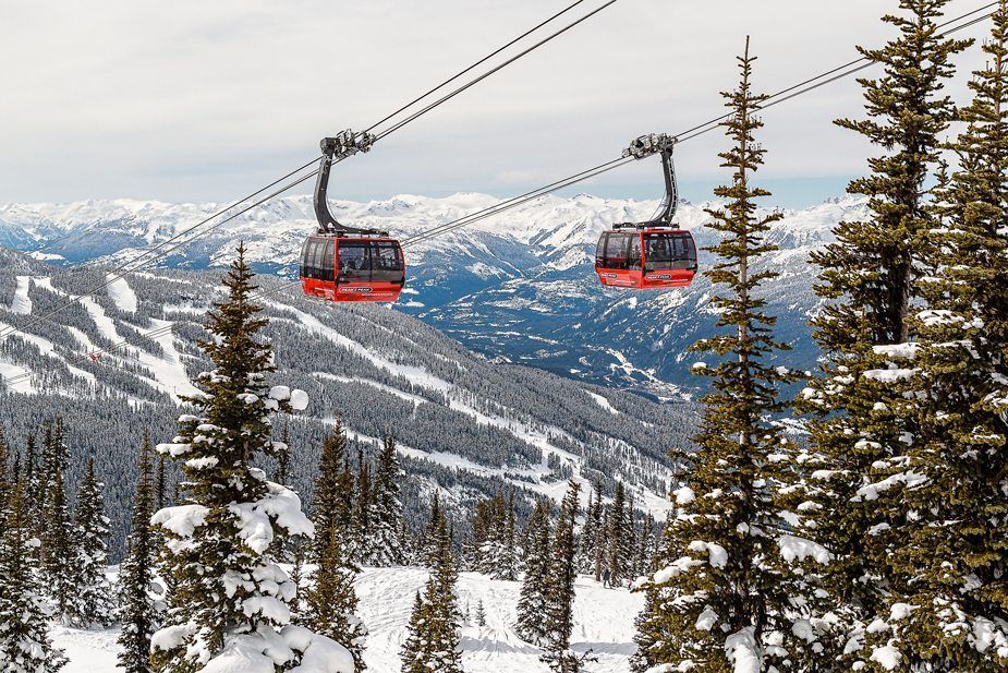 A couple of ski lifts going up a snow covered mountain.