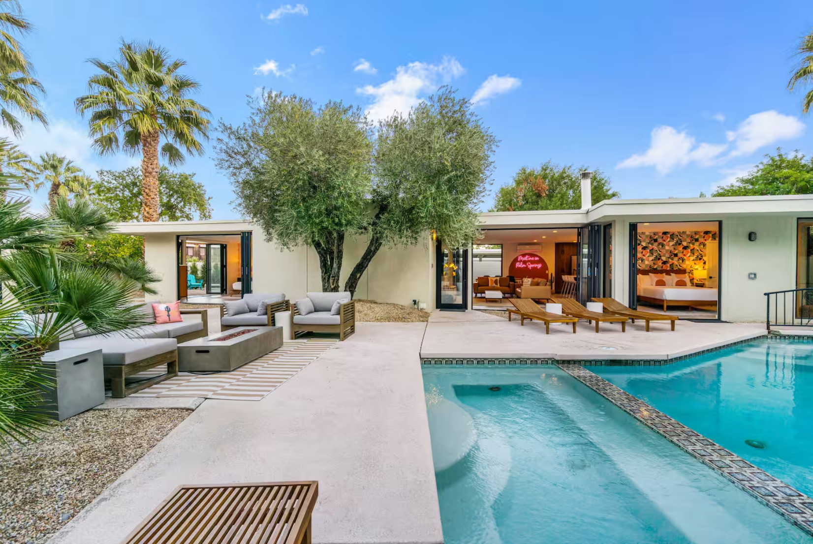 There is a large swimming pool in the backyard of a house.