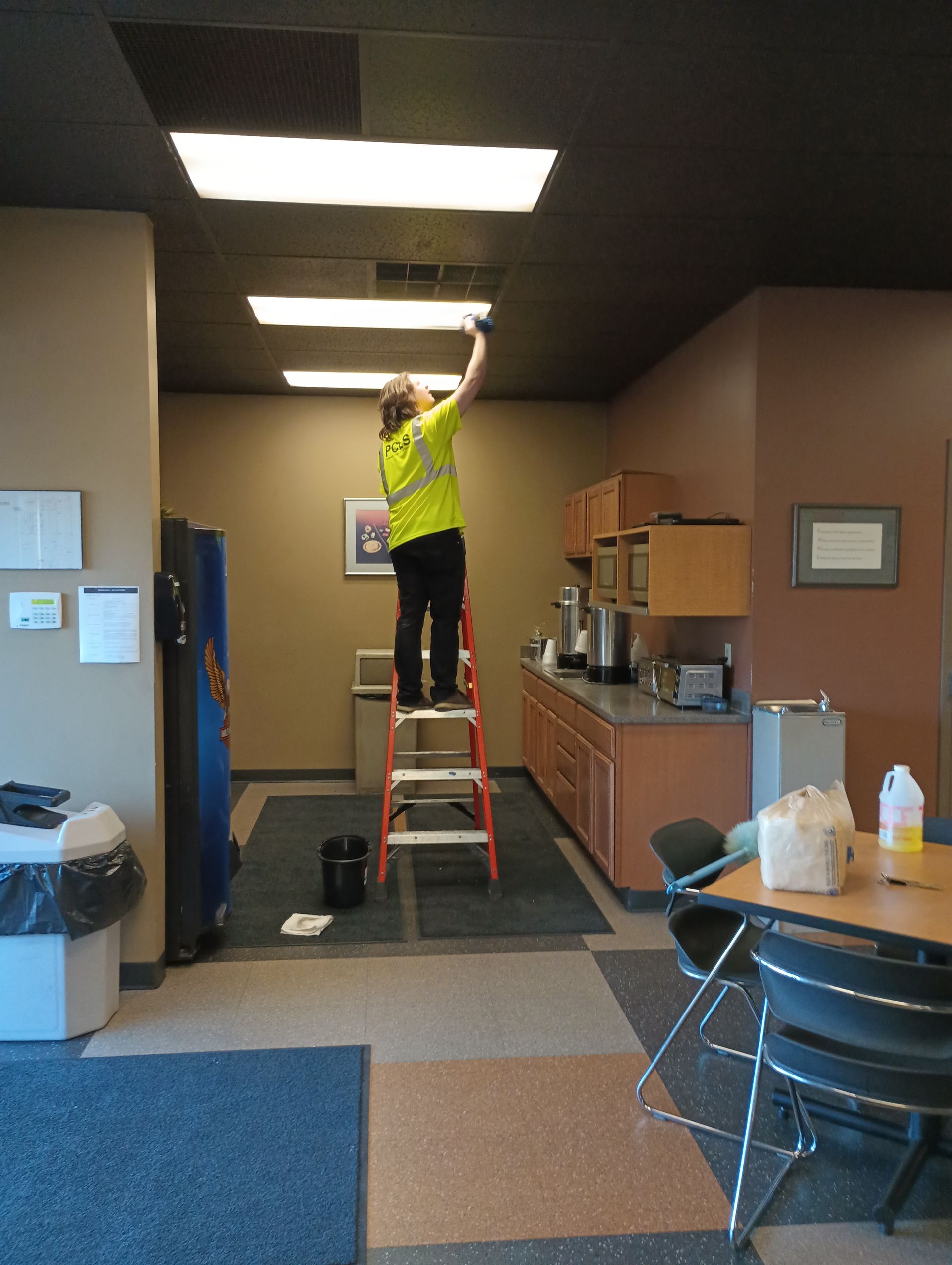 janitor cleaning light fixtures