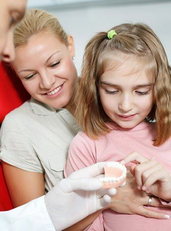 mom and daughter looking at dentures