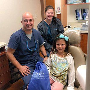 young child and Dr. Haddad taking picture with Dr. Haddad