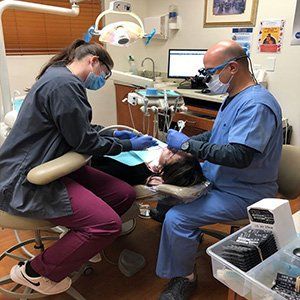 Dental assistant and Dr. Haddad administering dental services