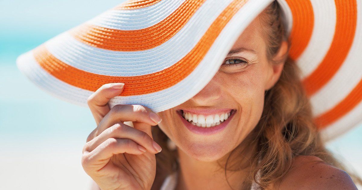 woman smiling with orange and white hat