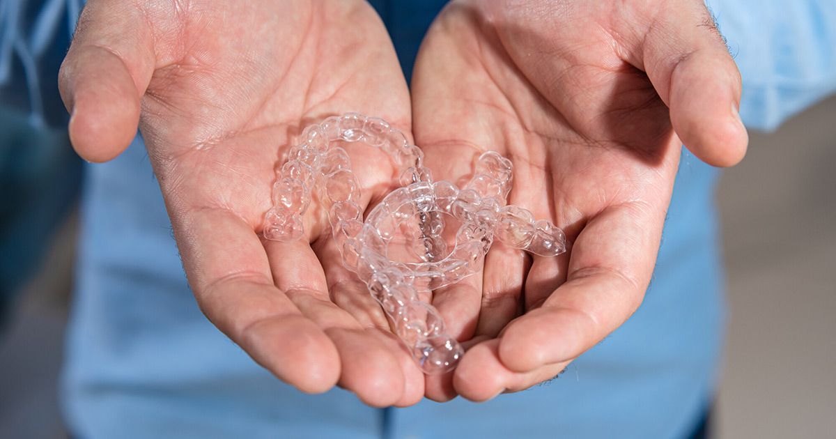 Invisalign aligners in the palm of the hand