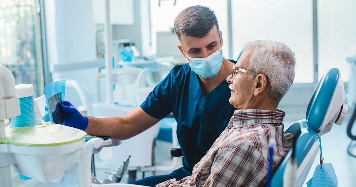 dental assistant talking to older man