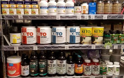 Shelves stocked with various dietary supplement bottles, mostly for keto, in a store.