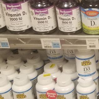 Shelves of vitamin D supplement bottles, various brands and dosages.