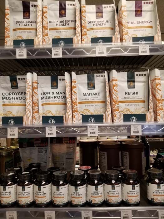 Shelf display of various health supplements: powders and capsules.