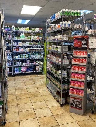 Shelves of supplements in a health store, with tiled floor, and overhead fluorescent lights.