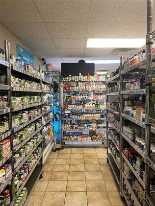 Shelves of supplements and vitamins in a well-stocked store aisle.