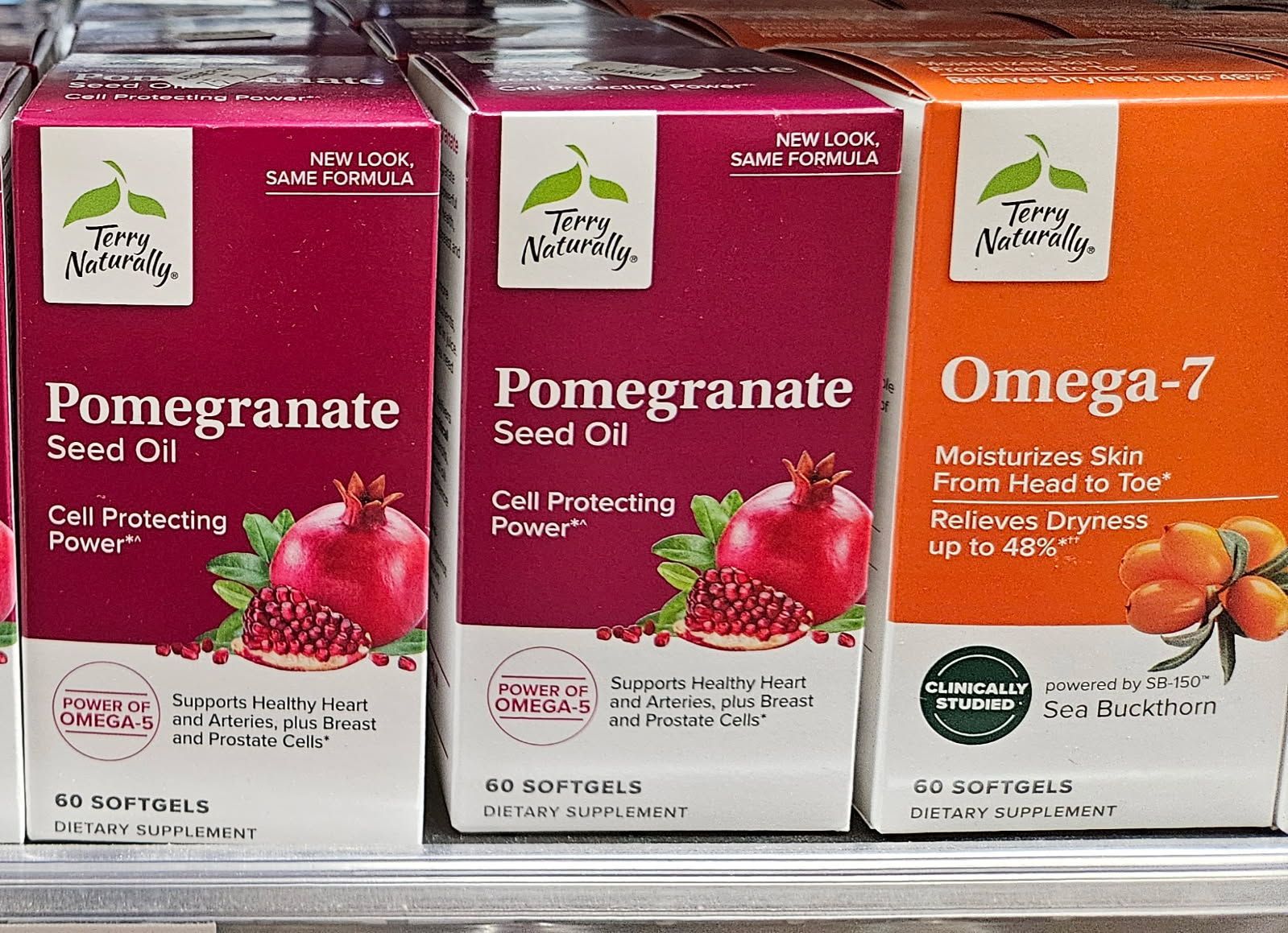 Boxes of dietary supplements: pomegranate seed oil and Omega-7, with fruit illustrations.