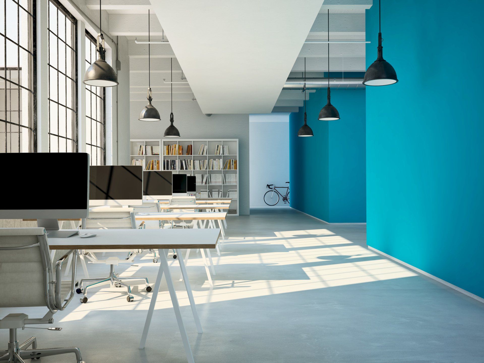 A modern office with blue walls and white desks and chairs.