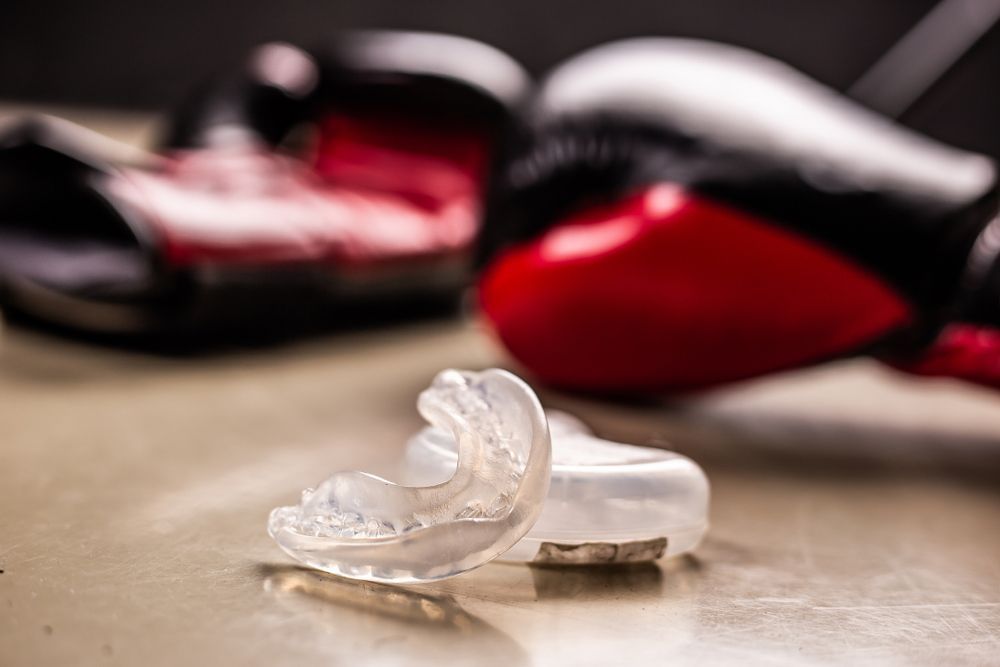 Mouthguard With Boxing Gloves Background — Denture Care in Berserker, QLD