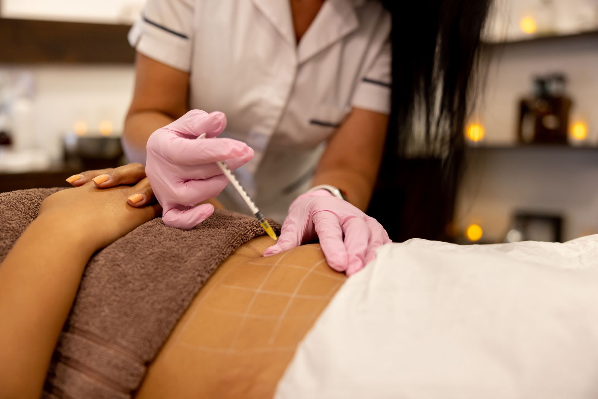 A woman is getting an injection on her stomach in a beauty salon.