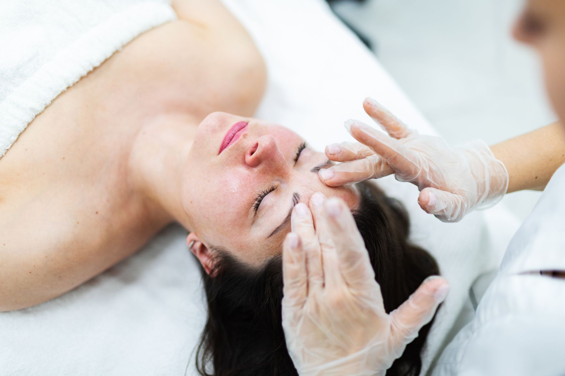 A woman is getting a facial massage.