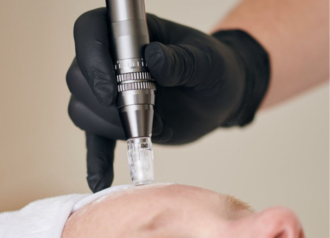 A woman is getting a facial treatment at a beauty salon using a device.