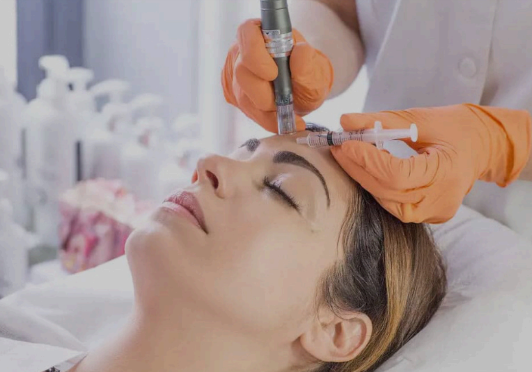 A woman is getting a facial treatment at a beauty salon using a device.