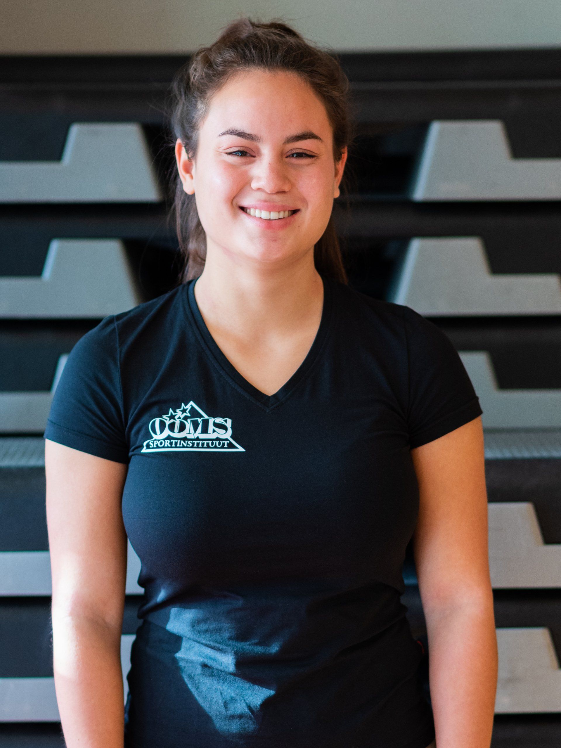 Een vrouw, gekleed in een zwart shirt met een berg erop