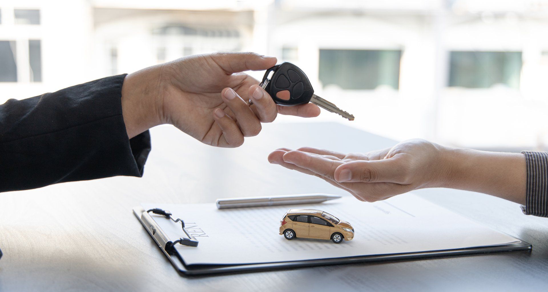 Car salesman gave the keys to the customers who signed the purchase contract legally, Successful completion of car sales, Purchase contract and key delivery.