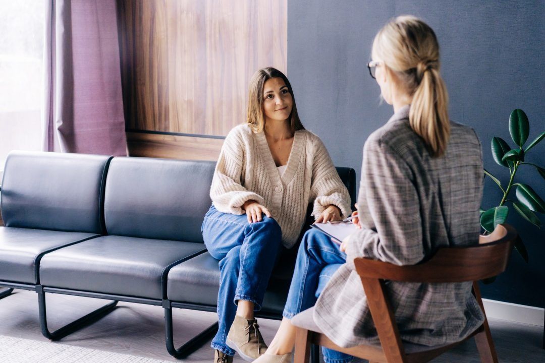 Woman talking to a therapist in an office setting.