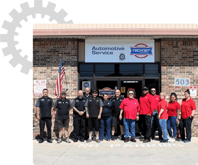 Phil's Service team standing in front of the automotive service building.