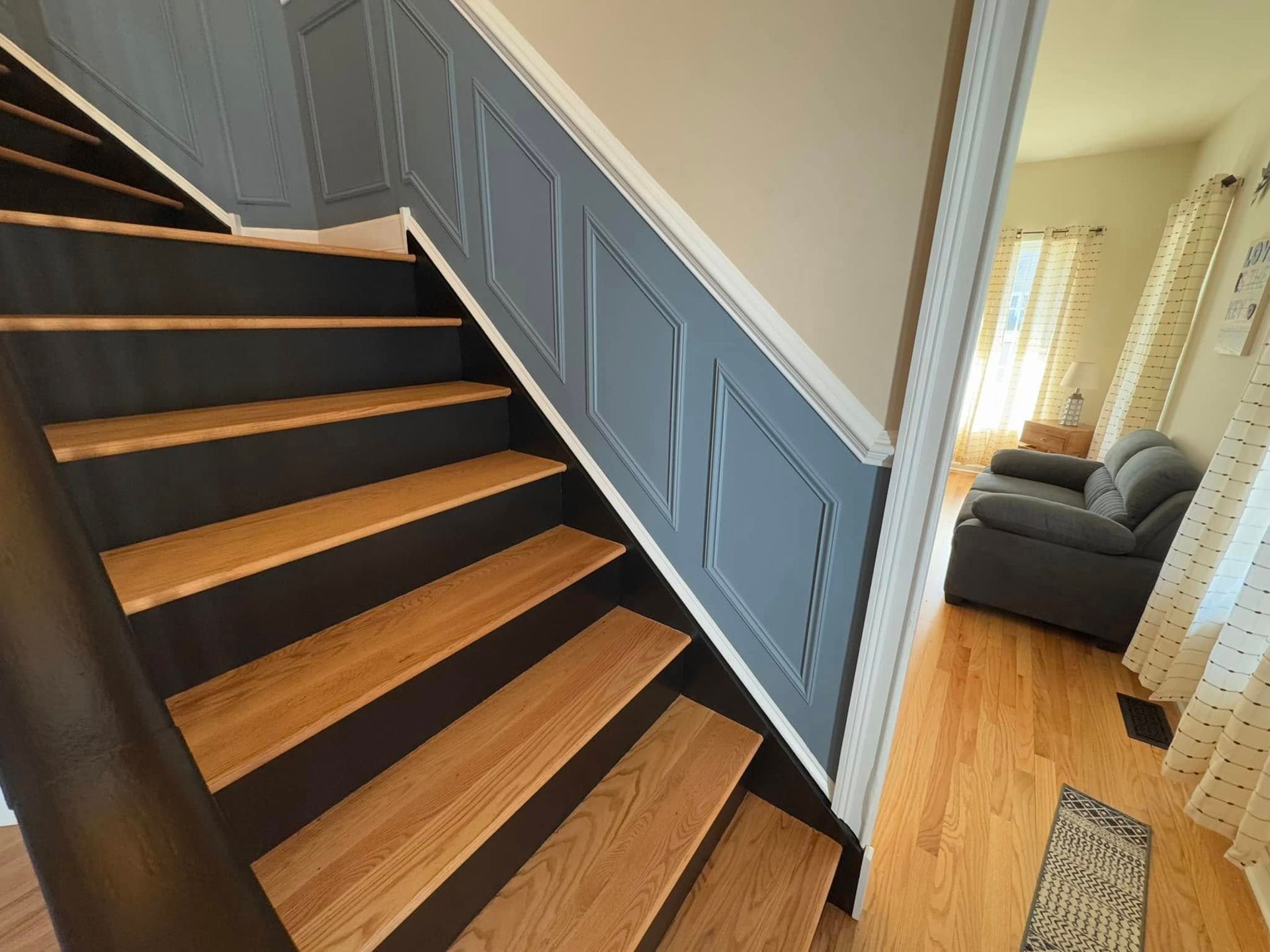 An empty room with a curved staircase and a large window