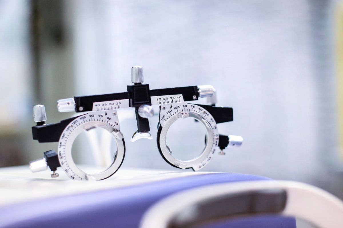 Eye exam equipment: trial frame resting on a light-colored surface with blurred background.