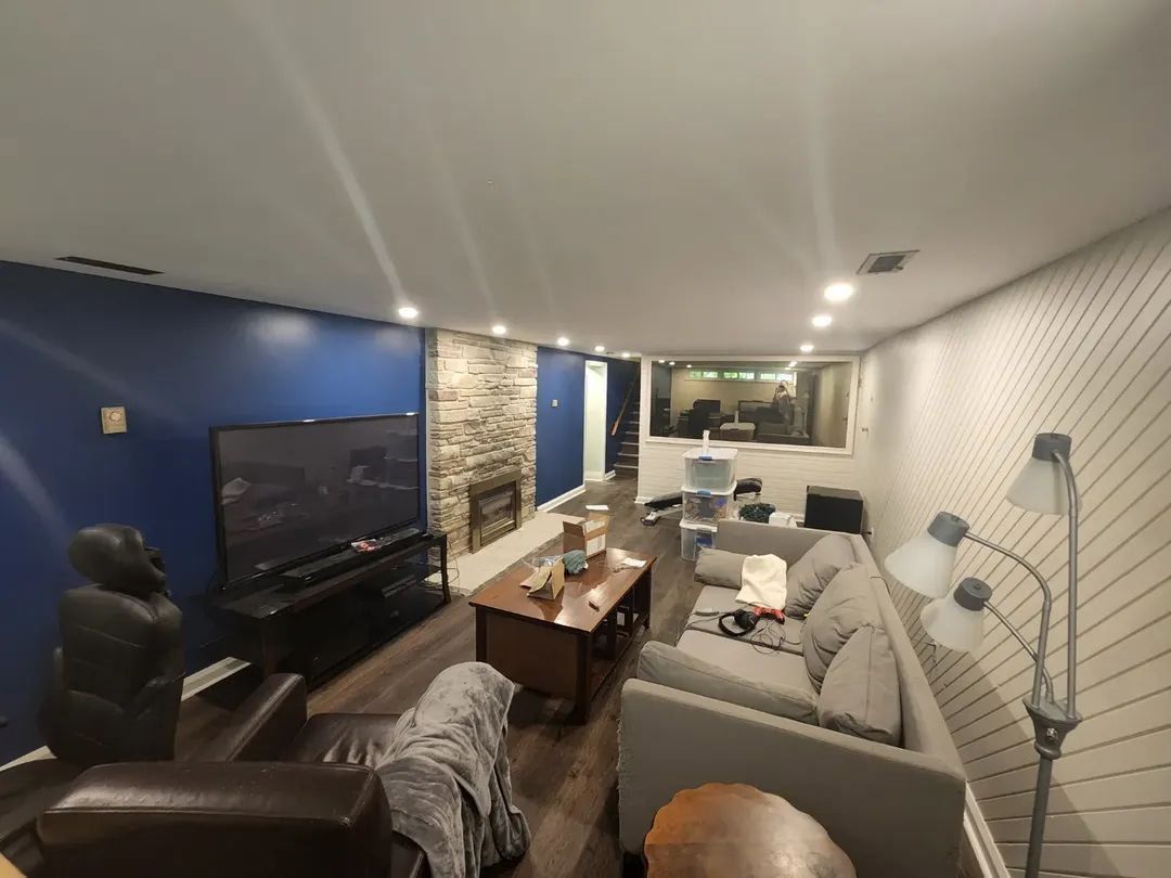 Living room with a gray couch, TV, fireplace, and blue and white walls.