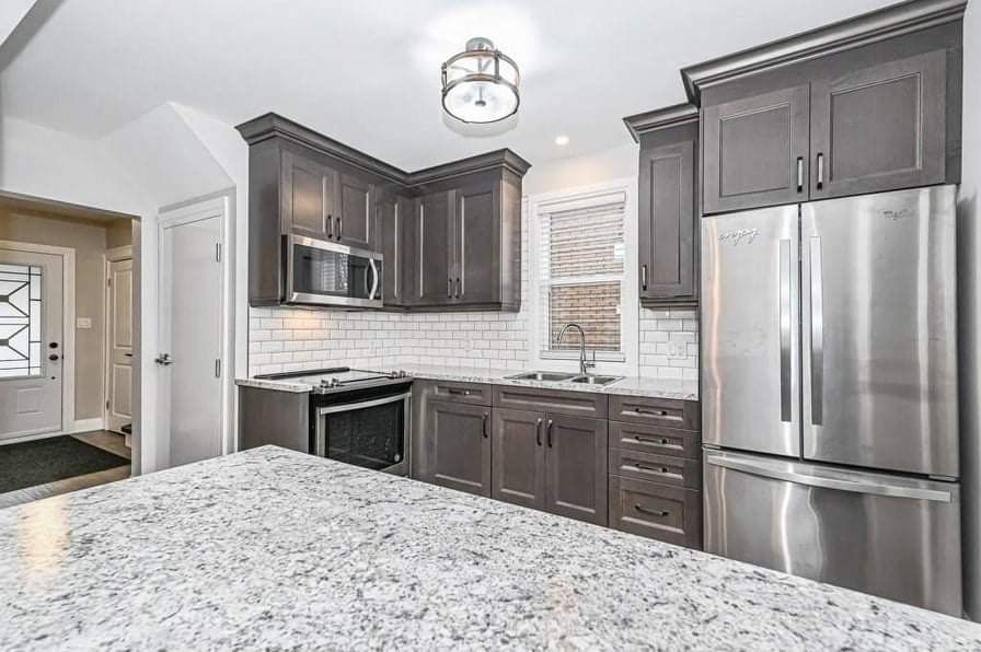 Kitchen with wood cabinets, island with stools, and dining area with large table and chairs.
