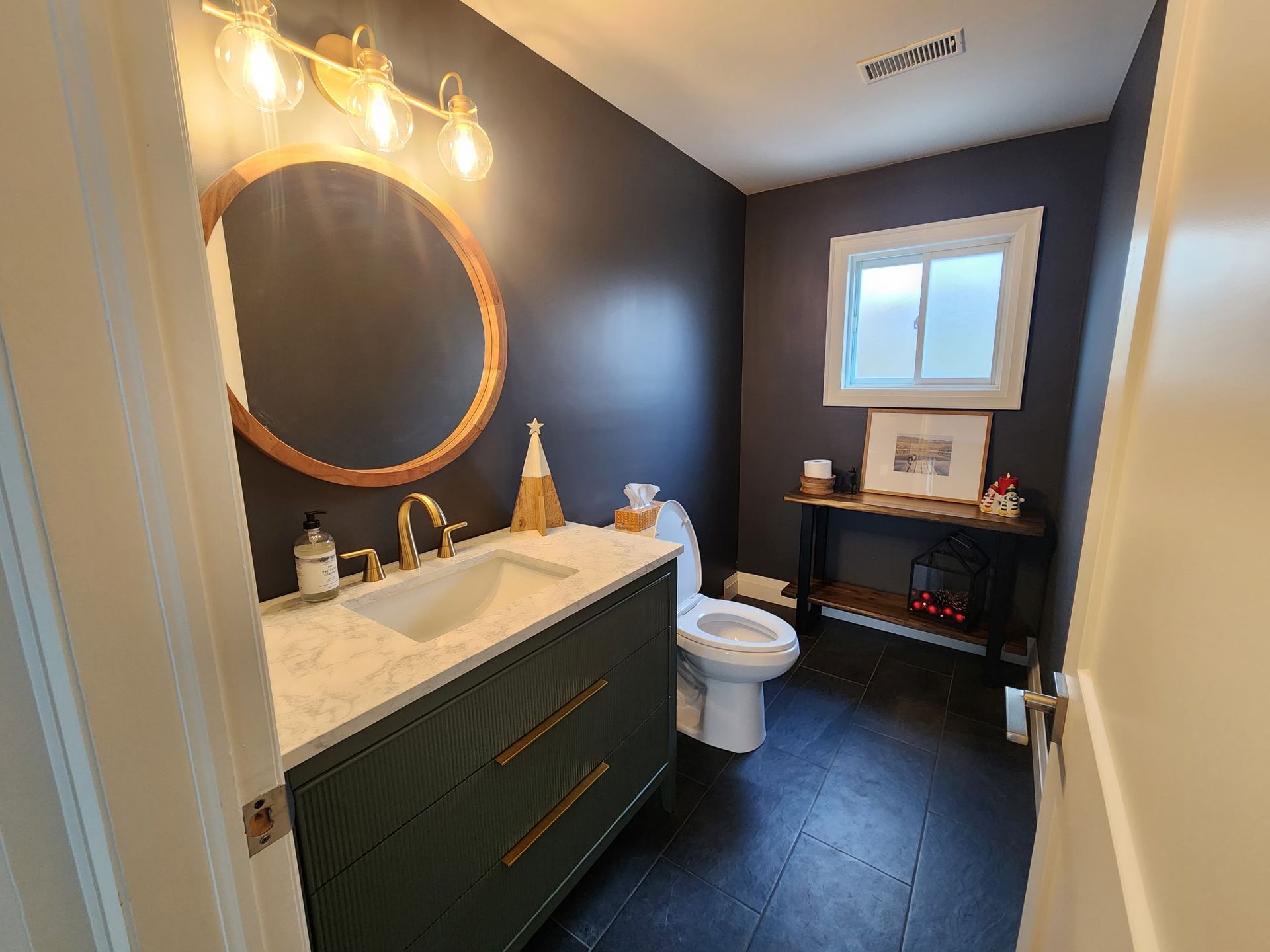 Small bathroom with shower stall and vanity. Light brown shower tiles, light gray walls, white sink.
