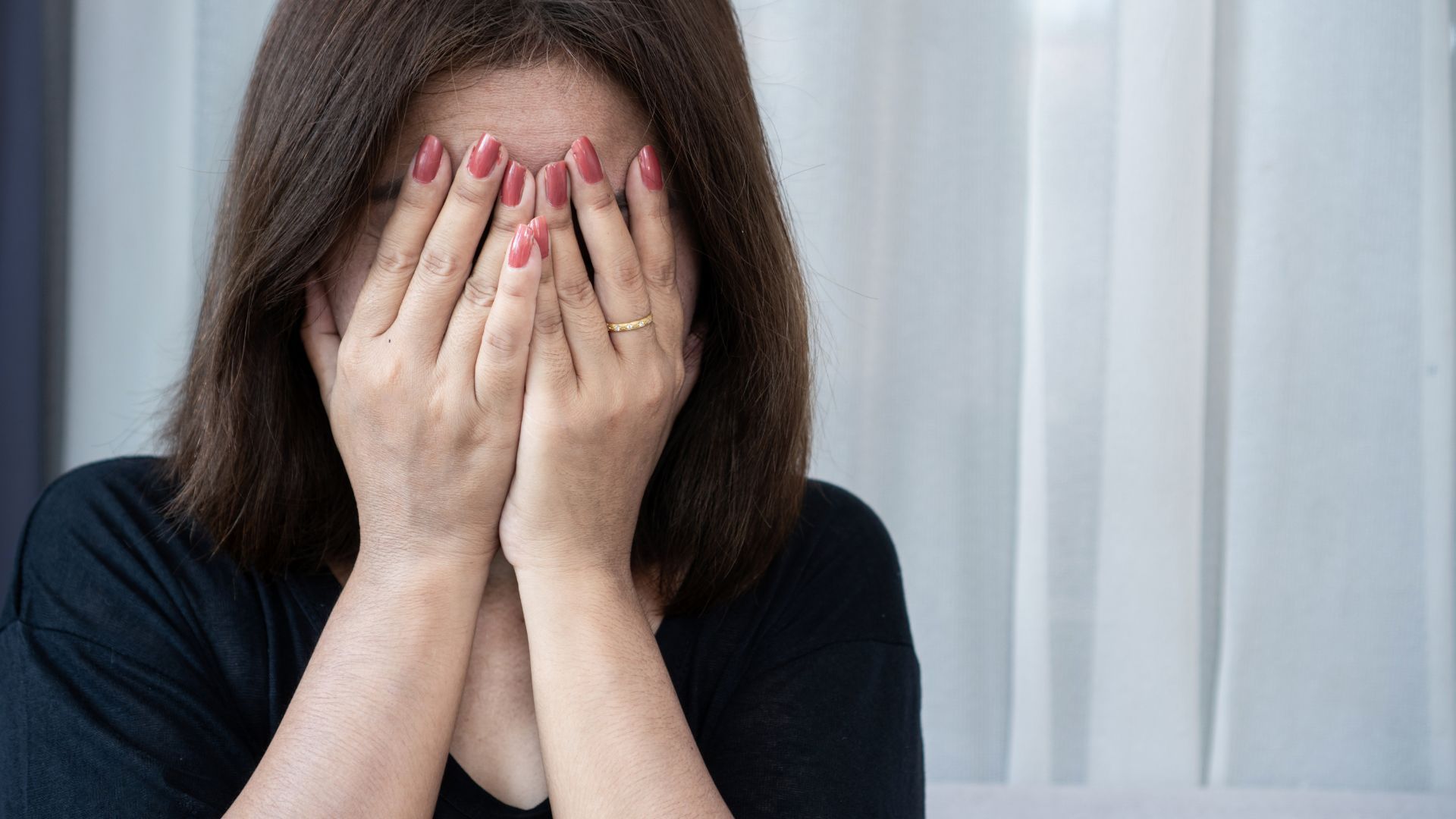 Silhouetted couple arguing near a window, arms raised in a heated discussion.