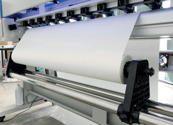 Impresora de gran formato con rollo de papel blanco.