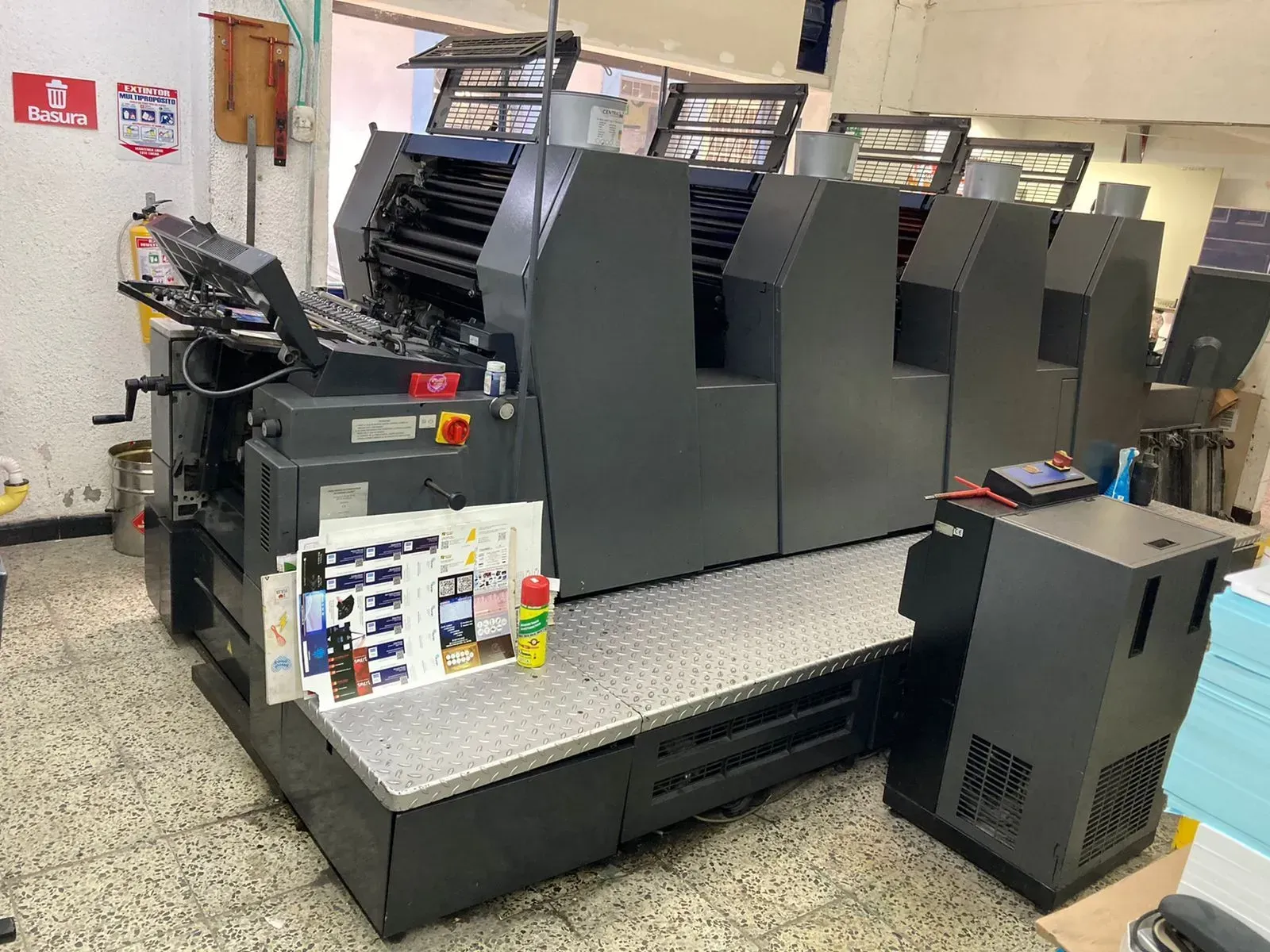 Una imprenta grande y gris en un taller de impresión.