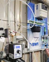 Apparecchiature industriali per la filtrazione dell'acqua con tubi, manometri e un grande serbatoio etichettato 