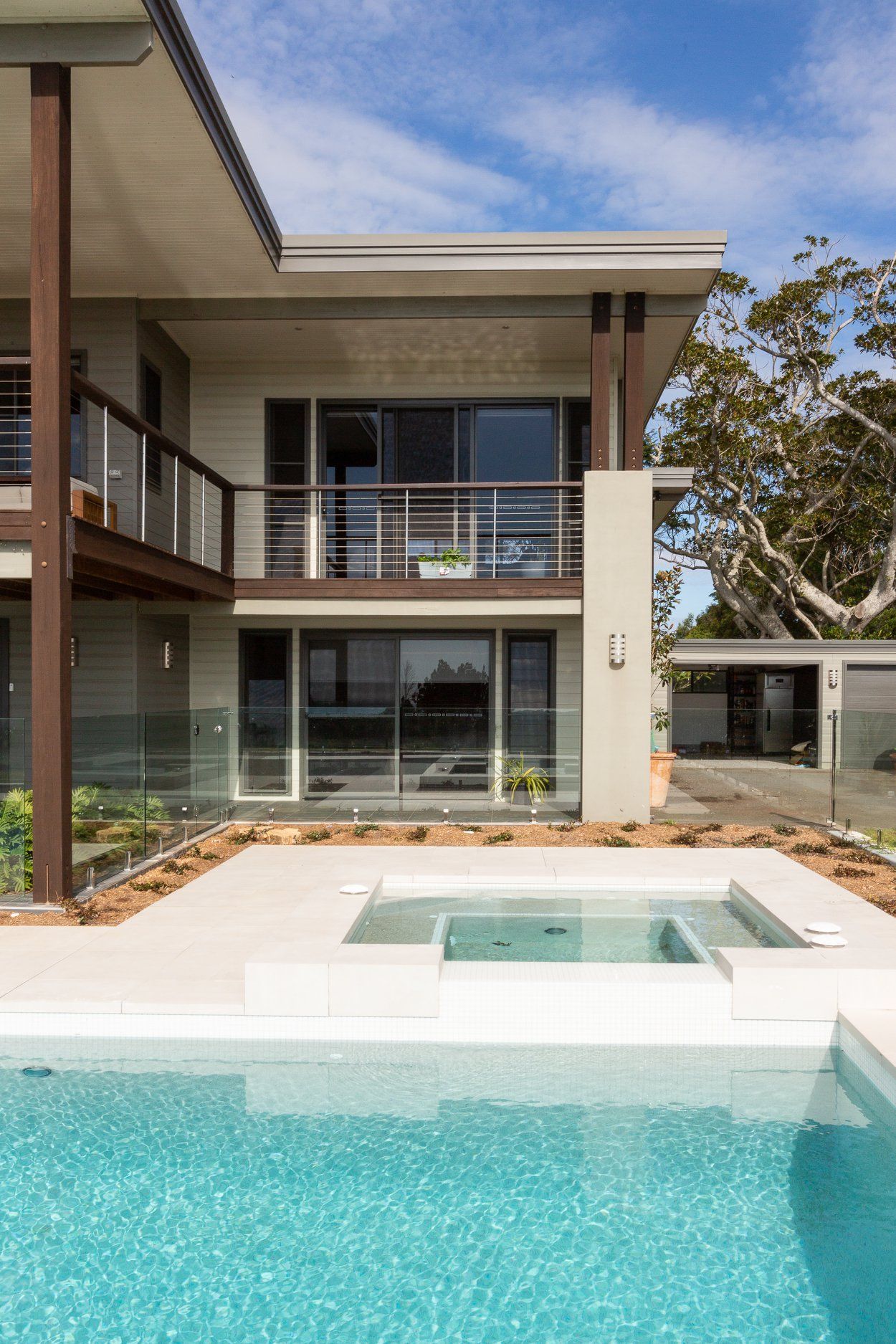 Swimming Pool With Fence Under The Bright Blue Sky With White Clouds — Profile Pools & Landscaping In Pottsville, NSW