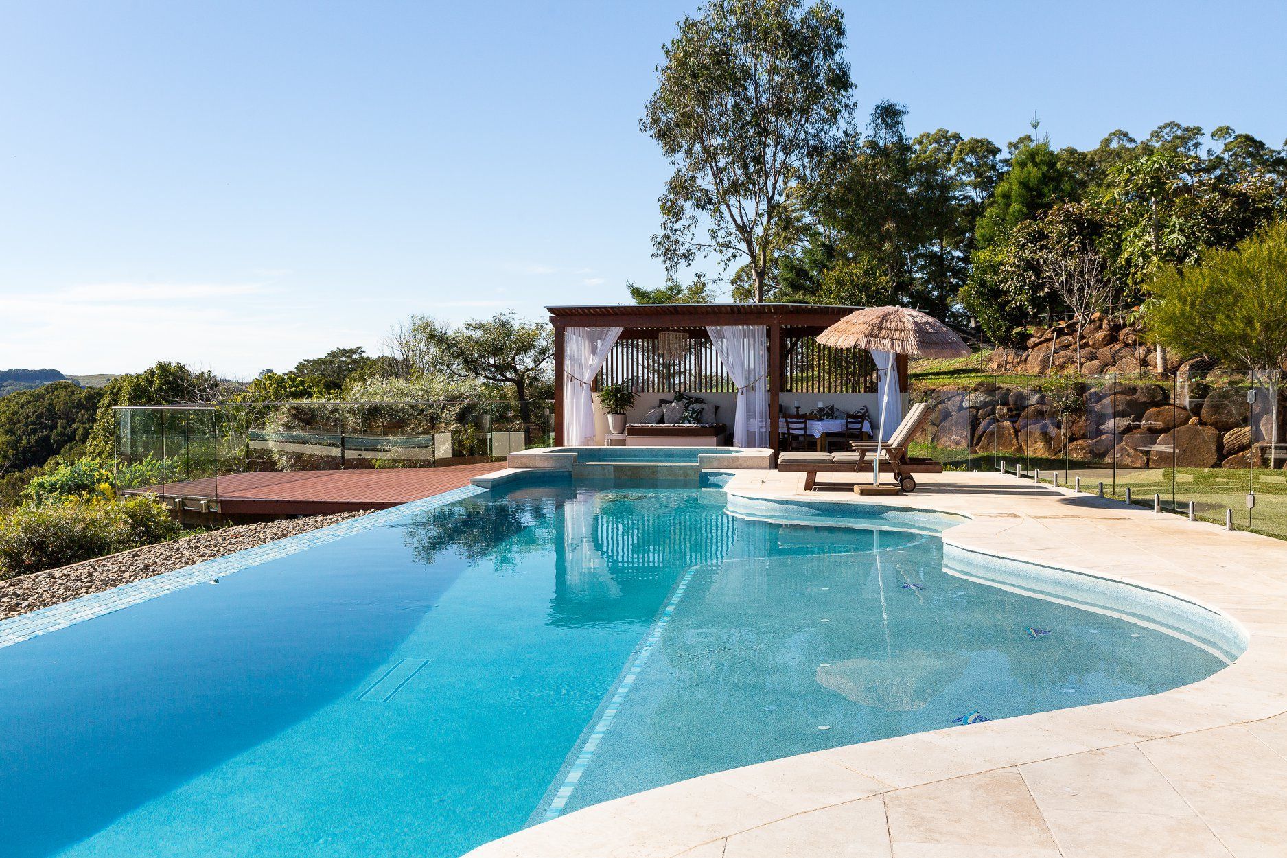 A large Swimming pool with a Gazebo in the Background — Profile Pools & Landscaping In Byron Bay, NSW