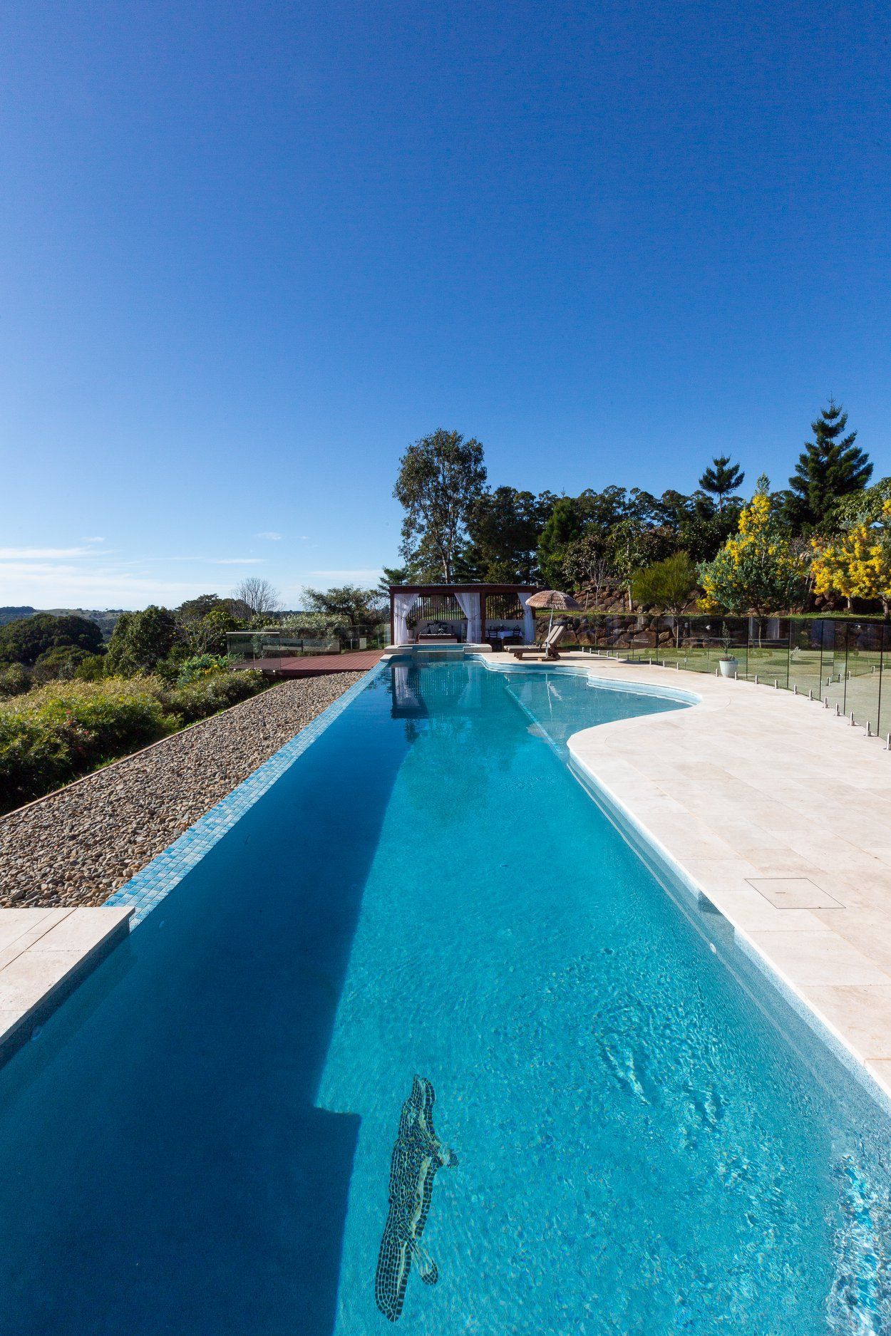 A Very long Swimming pool Surrounded by trees on a Sunny day — Profile Pools & Landscaping In Byron Bay, NSW