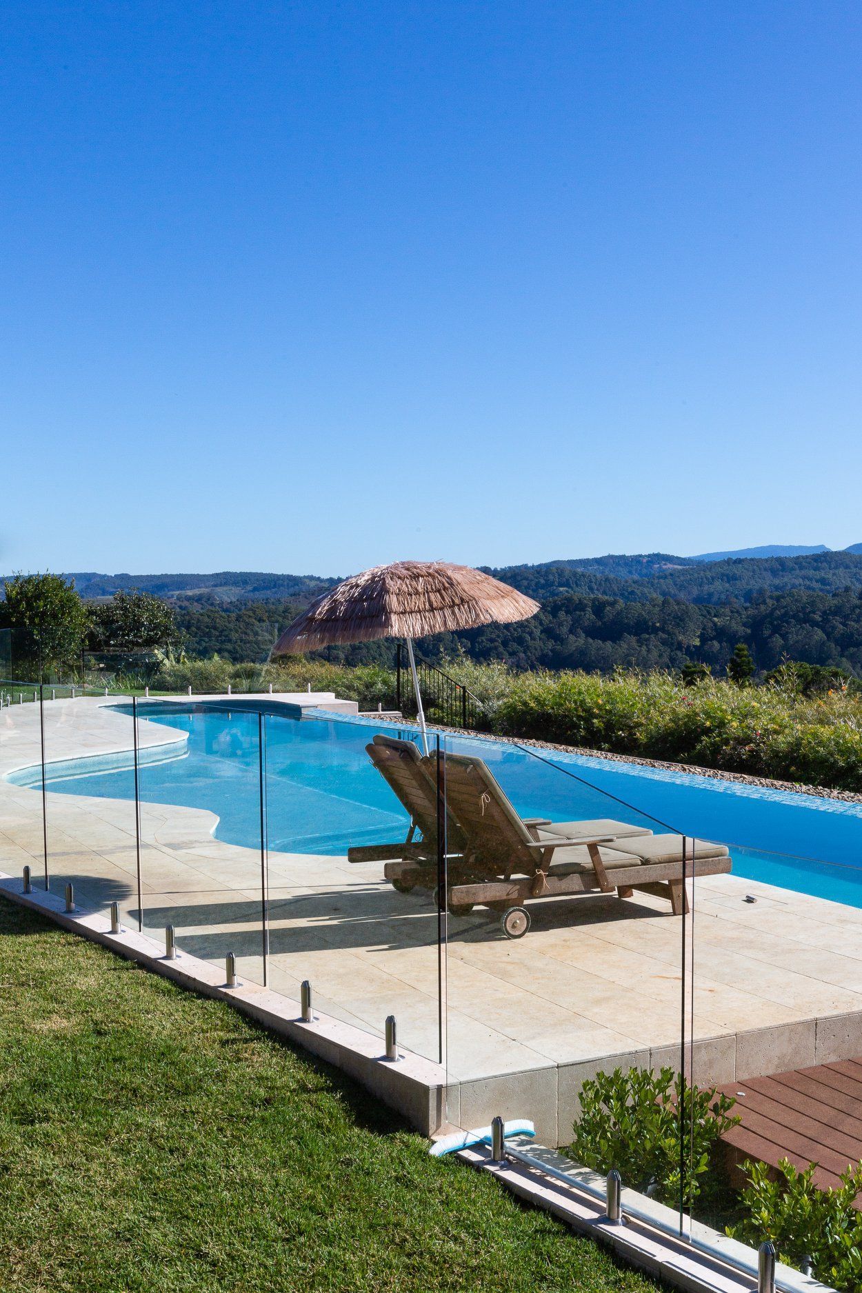 Infinity Swimming Pool With Glassy Safe Fence And Hardwood Decking Overlooking Landscape — Profile Pools & Landscaping In Byron Bay, NSW
