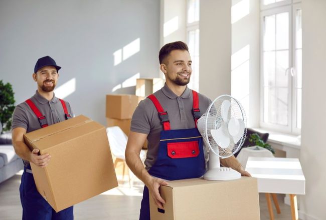 Two men carrying moving boxes