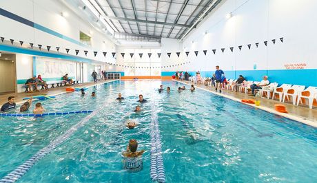 A large indoor swimming pool with stairs leading to it