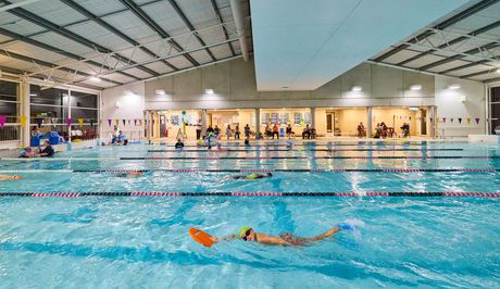 A large indoor swimming pool with stairs leading to it.
