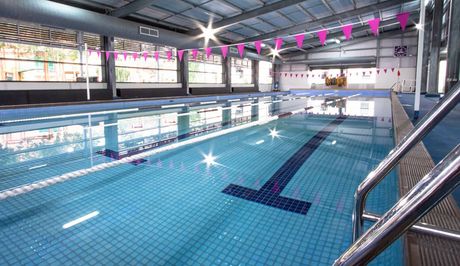 A large indoor swimming pool with stairs leading to it.