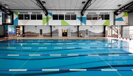 A large indoor swimming pool with stairs leading to it.