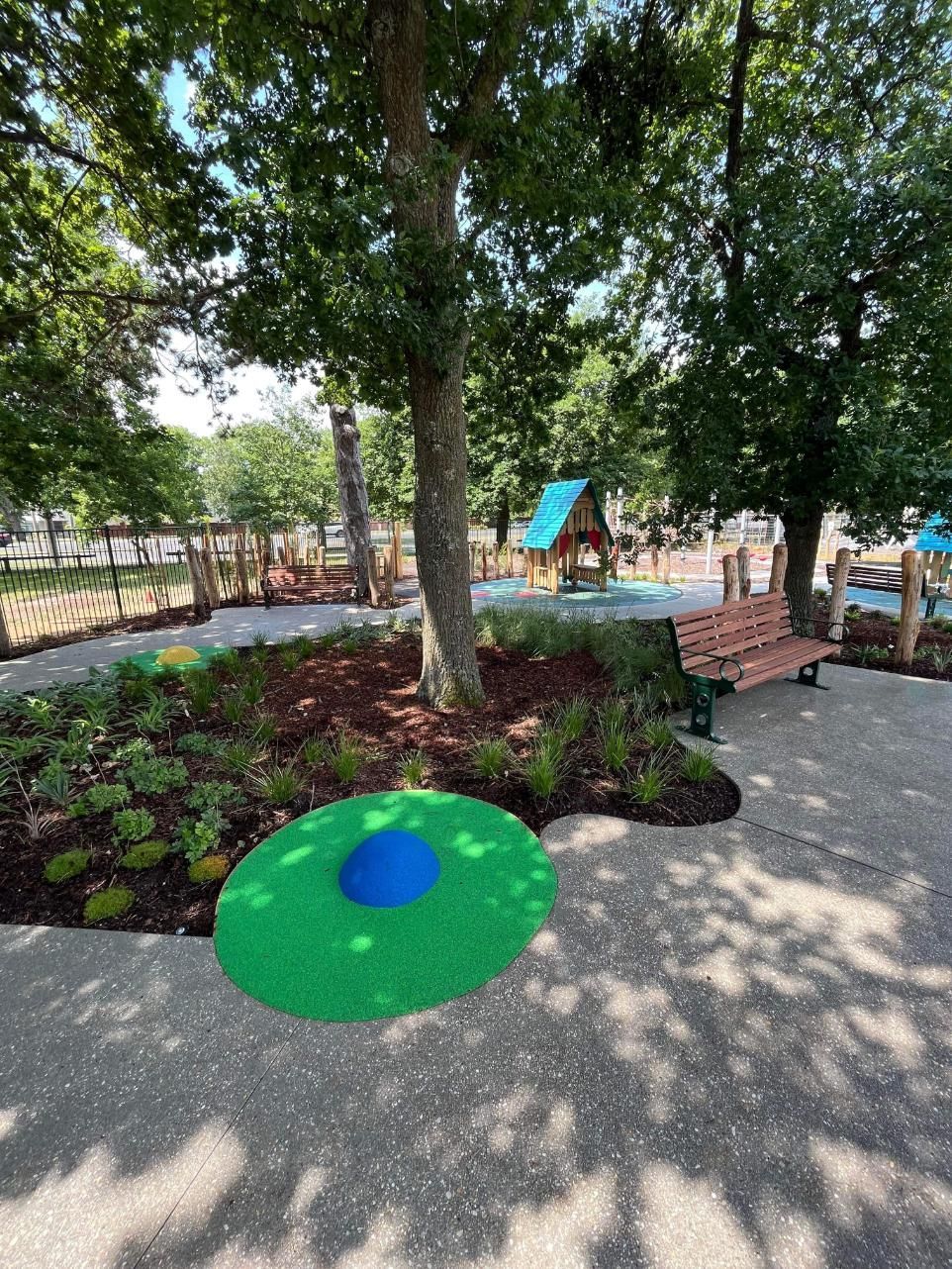 A green and blue circle is sitting in the middle of a park.