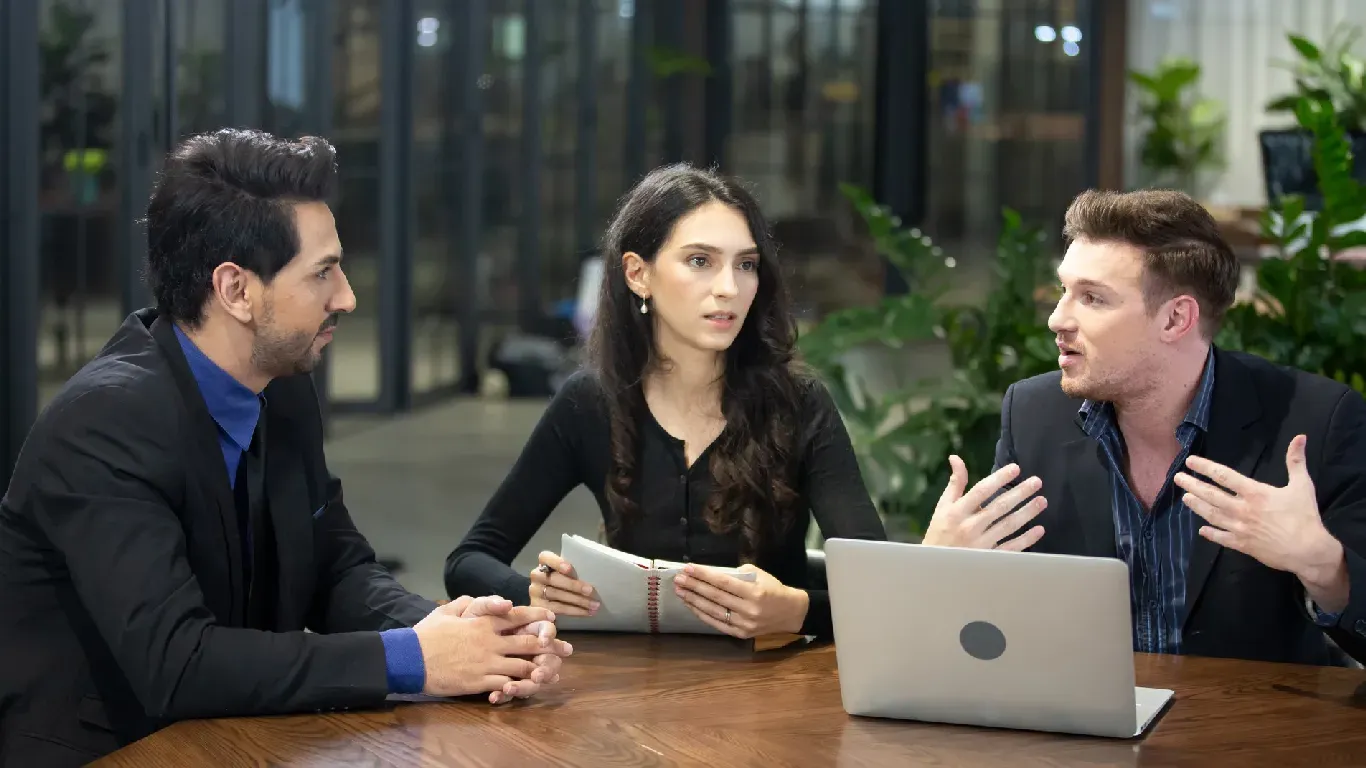A group of people are sitting at a table in a room.