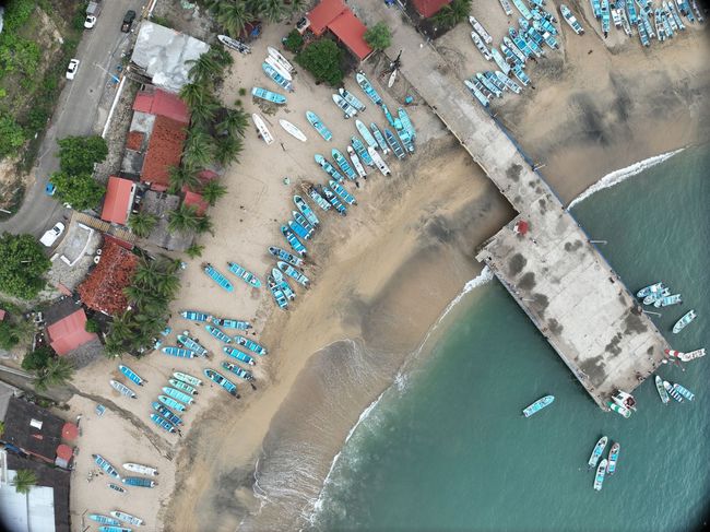 Una vista aérea de una playa con barcos y un muelle.