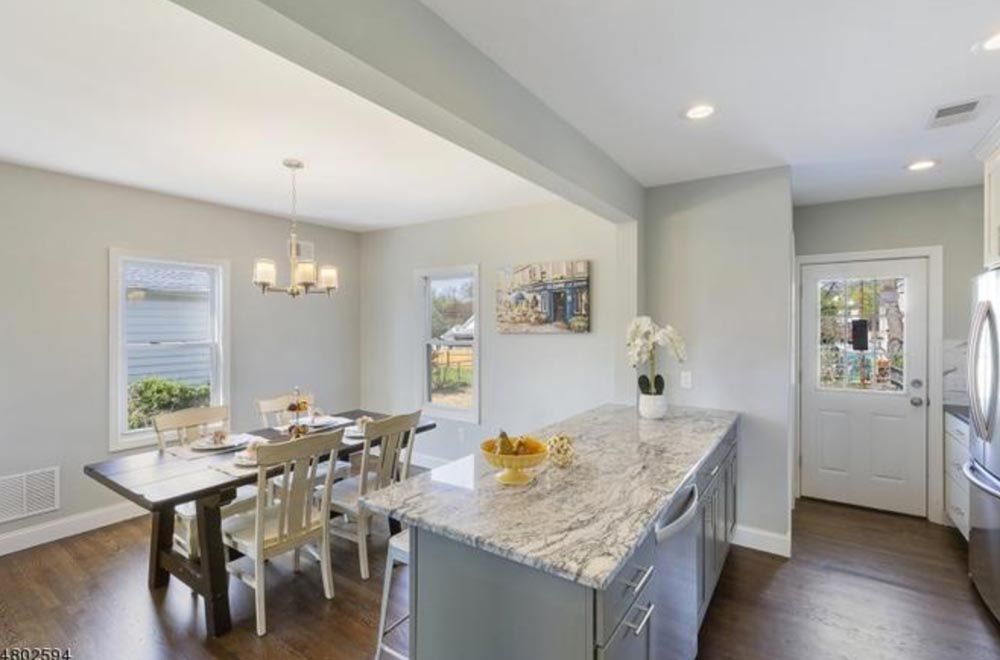 Open-concept kitchen and dining area with granite countertops and natural light, in Scotch Plains, NJ