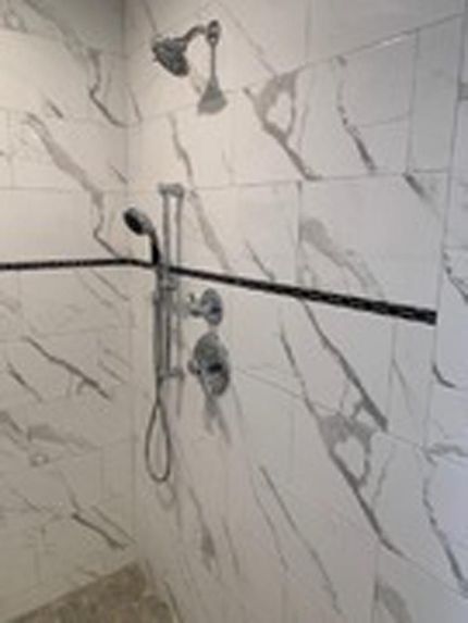 Luxury shower with marble tile and custom fixtures, completed by DMF Construction in Scotch Plains, NJ.