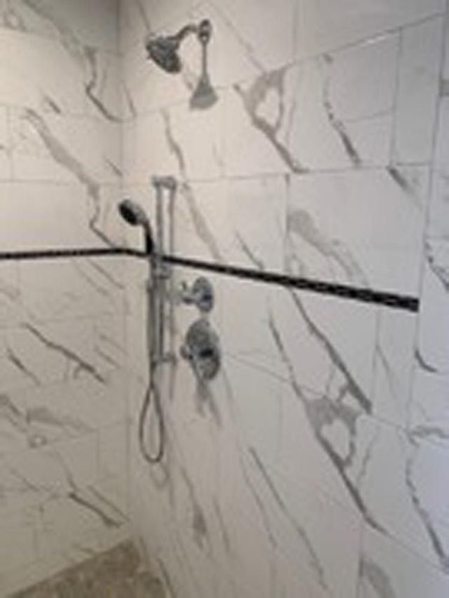 Luxury shower with marble tile and custom fixtures, completed by DMF Construction in Scotch Plains, NJ.