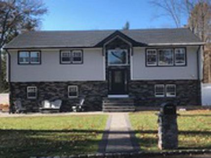 Exterior renovation of a split-level home with stone facade and updated siding by DMF Construction in Scotch Plains, NJ.